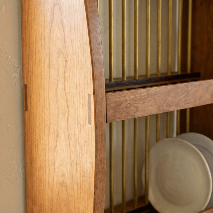 Wooden cabinet with a glass door displaying ceramic plates.