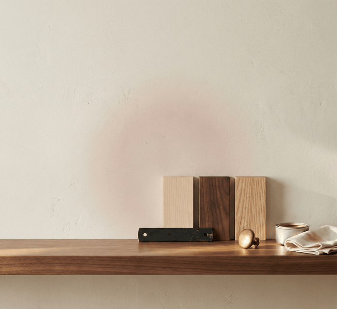 Wooden cutting boards and a knife on a wooden shelf against a plain wall.