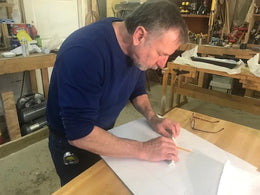 Man working on a project at a table in a workshop