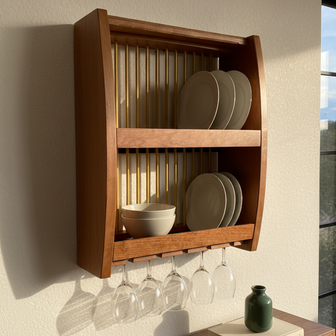 Wooden wall-mounted shelf with plates, bowls, and wine glasses on a neutral wall.