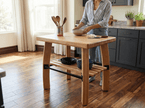 Person preparing food at a wooden kitchen island with utensils and a bowl.